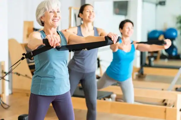 Toning Arms After 60: Empowering Womens Fitness Through Effective Weight Training 2 older woman doing weight training West Thurrock and resistance in the gym to tone upper arms