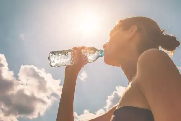 Hydration: The Secret Ingredient for a Toned Stomach and Enhanced Fitness 3 Image of woman drinking water to hydrate West Thurrock after run.