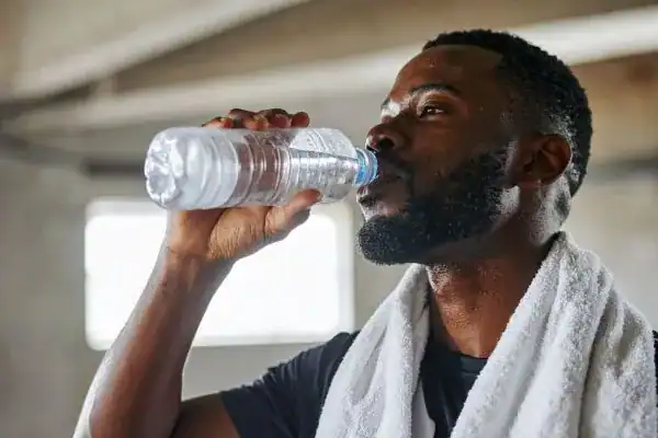 Hydration: The Secret Ingredient for a Toned Stomach and Enhanced Fitness 1 Image of man drinking water to improve hydration West Thurrock after work out.